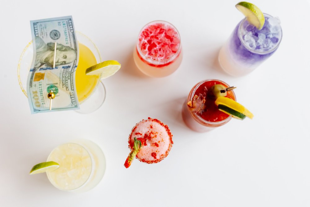 Brunch cocktails from above, including a mimosa garnished with an edible dollar bill