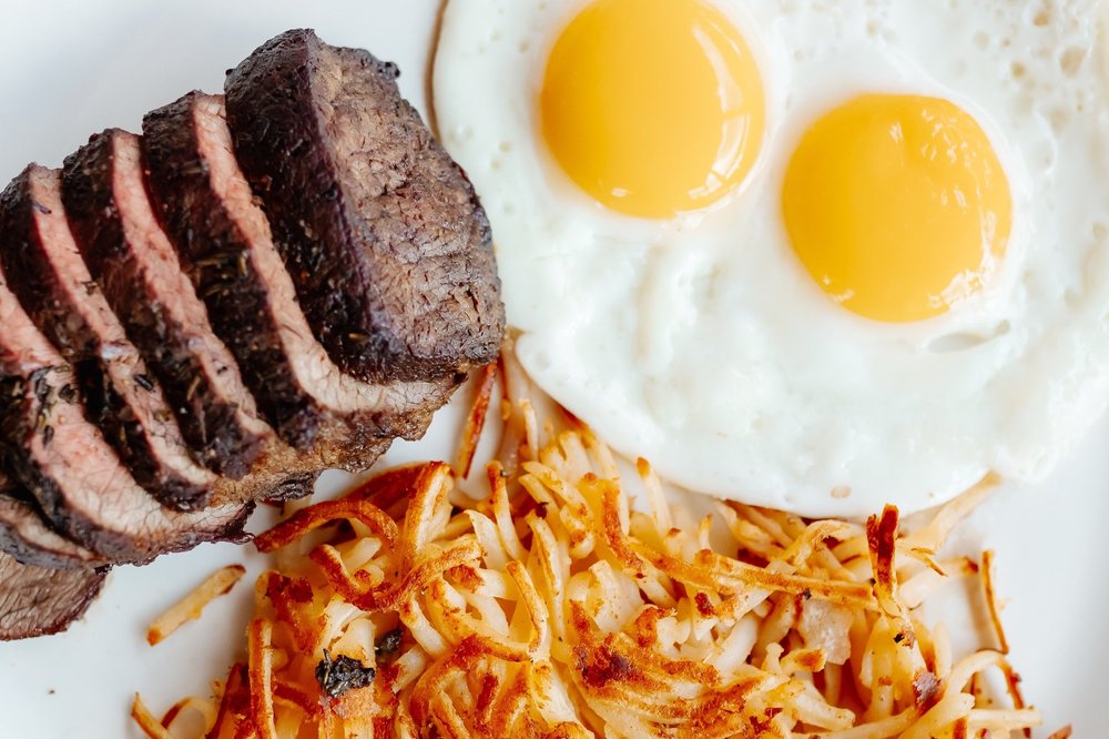 Sliced top sirloin with two sunny eggs and hash browns